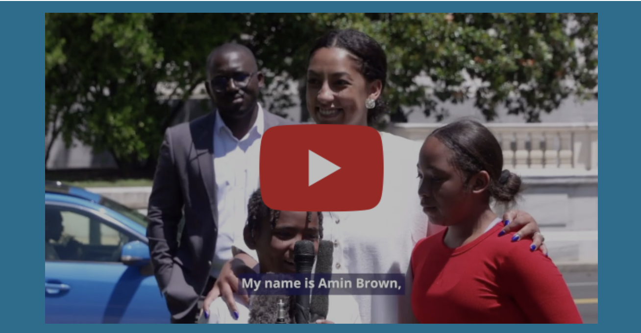 A still from the new "Broken Hope" video shows a man in the background and a woman in the foreground, flanked by two children